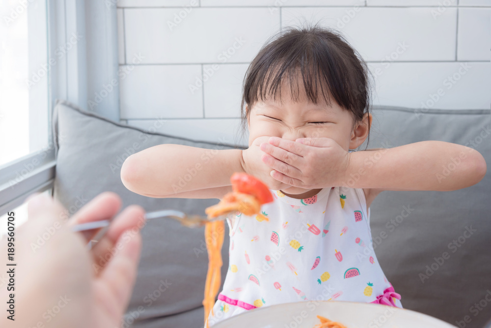 亚洲小女孩拒绝从她妈妈那里吃西红柿