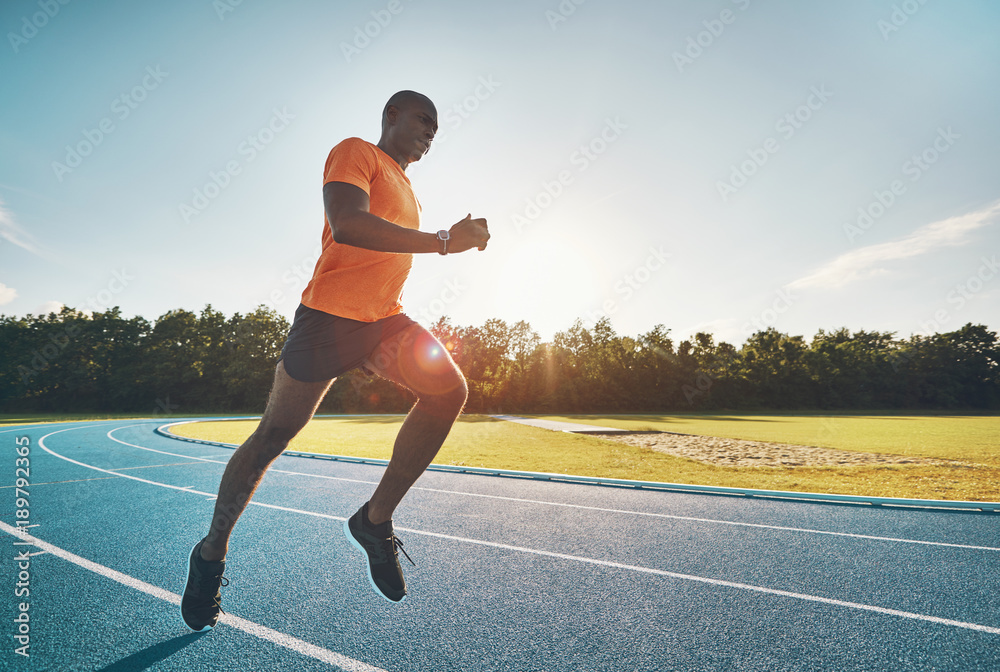 健康的年轻运动员独自在跑道上比赛