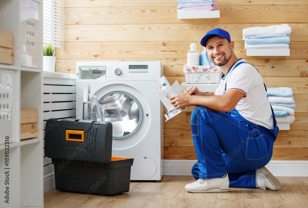 working man   plumber repairs  washing machine in   laundry