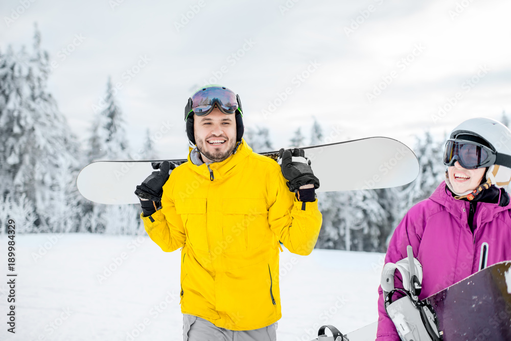 一对年轻夫妇寒假在雪山上滑雪板行走