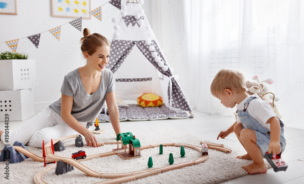 快乐家庭母子在游戏室玩具铁道玩耍