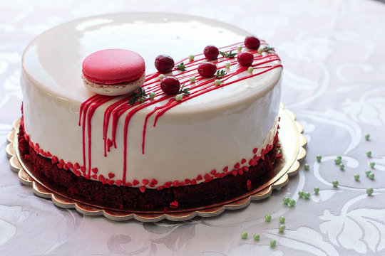用红色浆果和马卡龙装饰的美味白色自制蛋糕