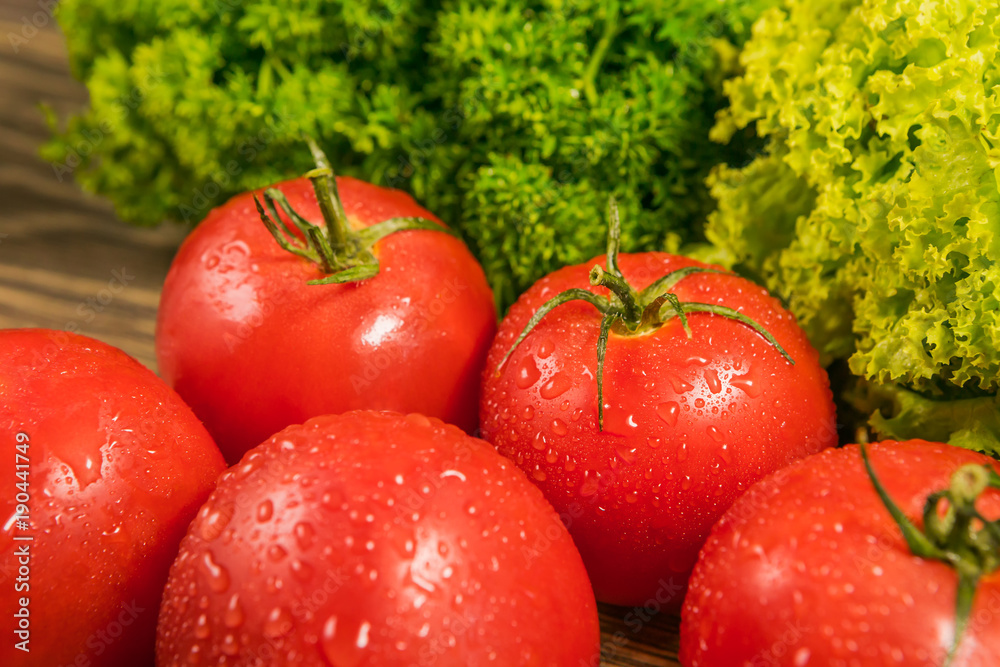 Ripe tomatoes on a rustic wooden table. Food ingredients. Background of vegetables.