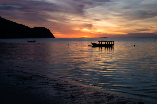 Magical sunset with traditional boat at a deserted beach near surf spot scar reef on Sumbawa, Indone