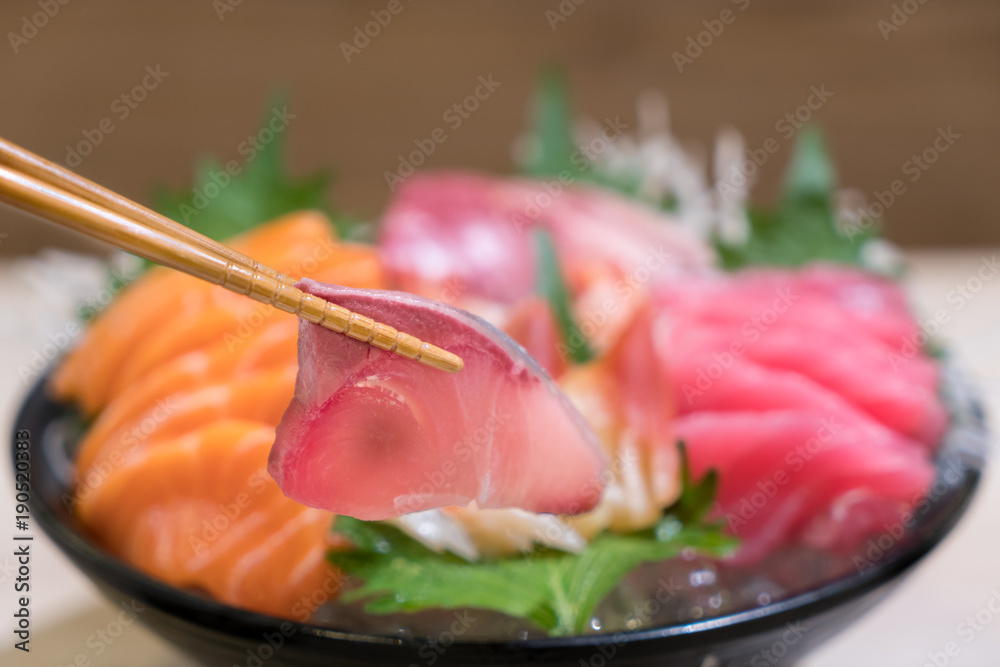 筷子配滨池生鱼片，黑碗冰上混合鱼片生鱼片。刺身三文鱼