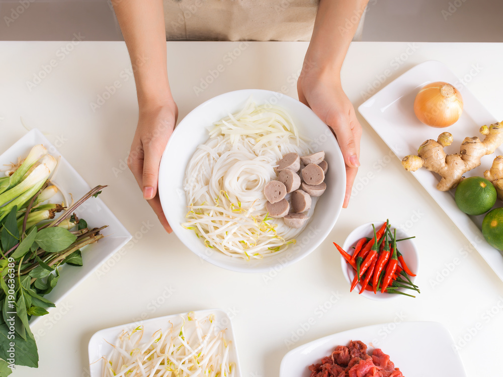 女厨师准备越南传统汤Pho bo，配香草、肉、米粉