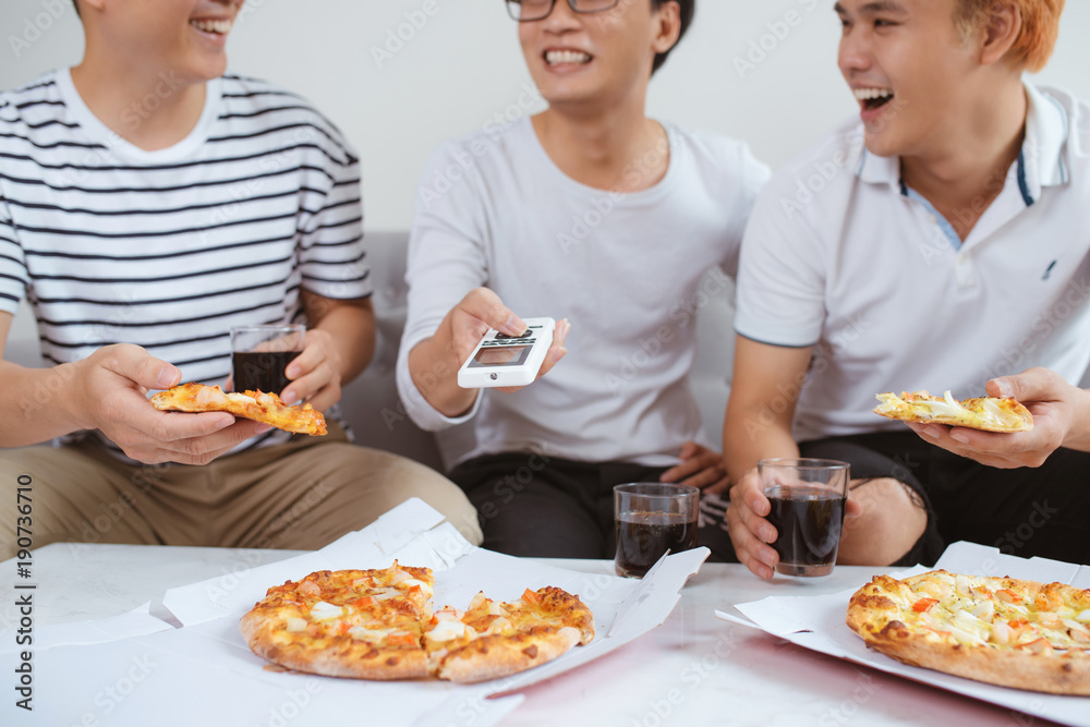 人们吃快餐。朋友们手拿披萨片