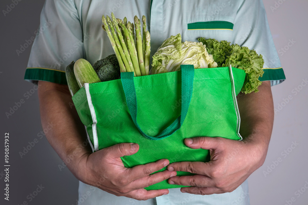 近距离手持混合有机绿色蔬菜的绿色食品袋，健康有机蔬菜