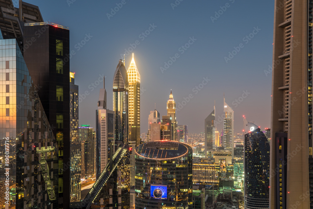 从屋顶上看，五颜六色的日落后，迪拜迪拜国际金融中心区的天际线。阿联酋迪拜。
