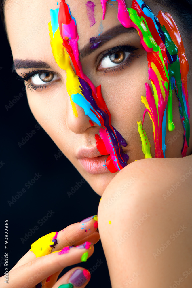 Beauty model girl with colorful paint on her face. Portrait of beautiful woman with flowing liquid p