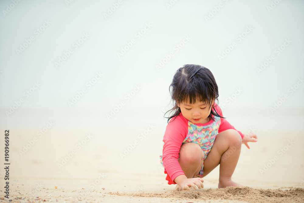 在海滩上玩耍的亚洲小女孩。