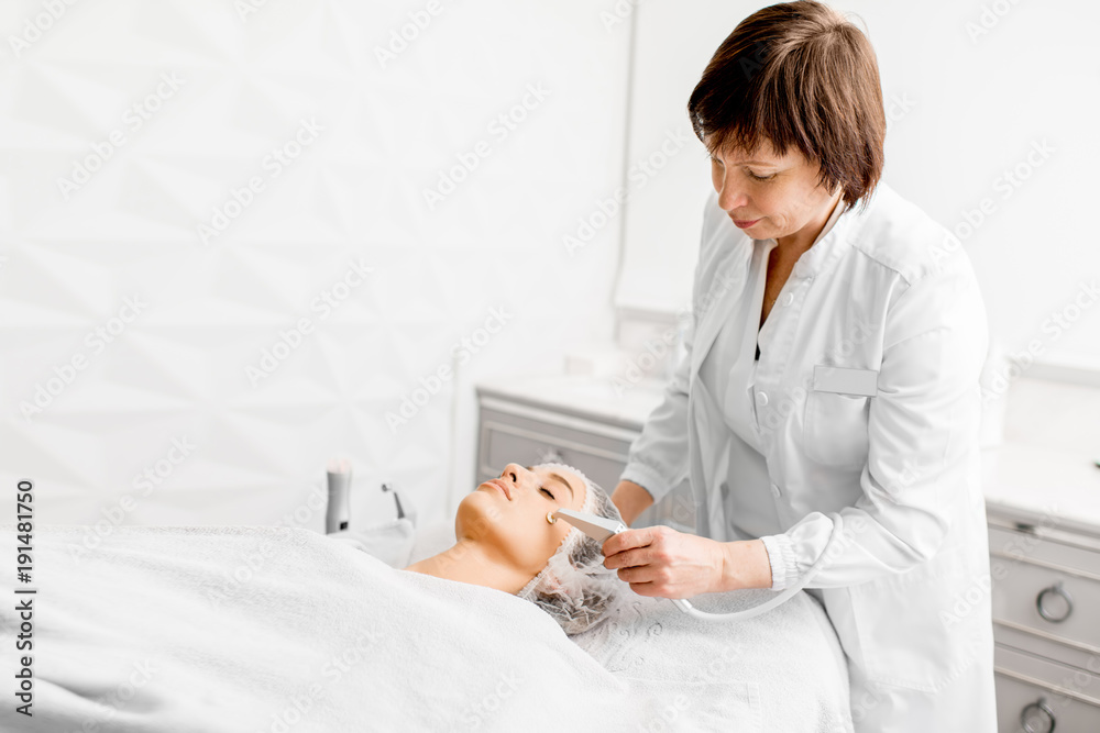 高级女性美容师在豪华医疗度假酒店为一位年轻客户做面部手术