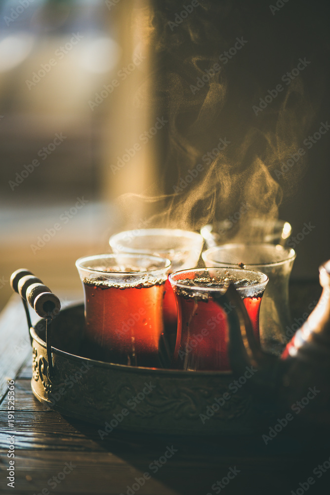 传统热气腾腾的土耳其茶，装在郁金香玻璃杯里，铜壶放在复古托盘里