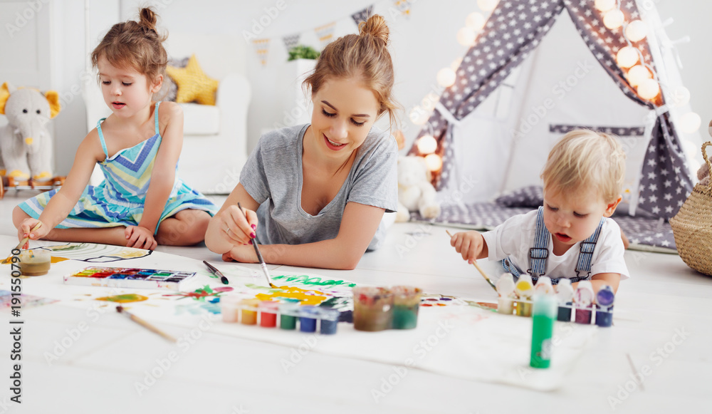 childrens creativity. mother and children draw paints in   playroom