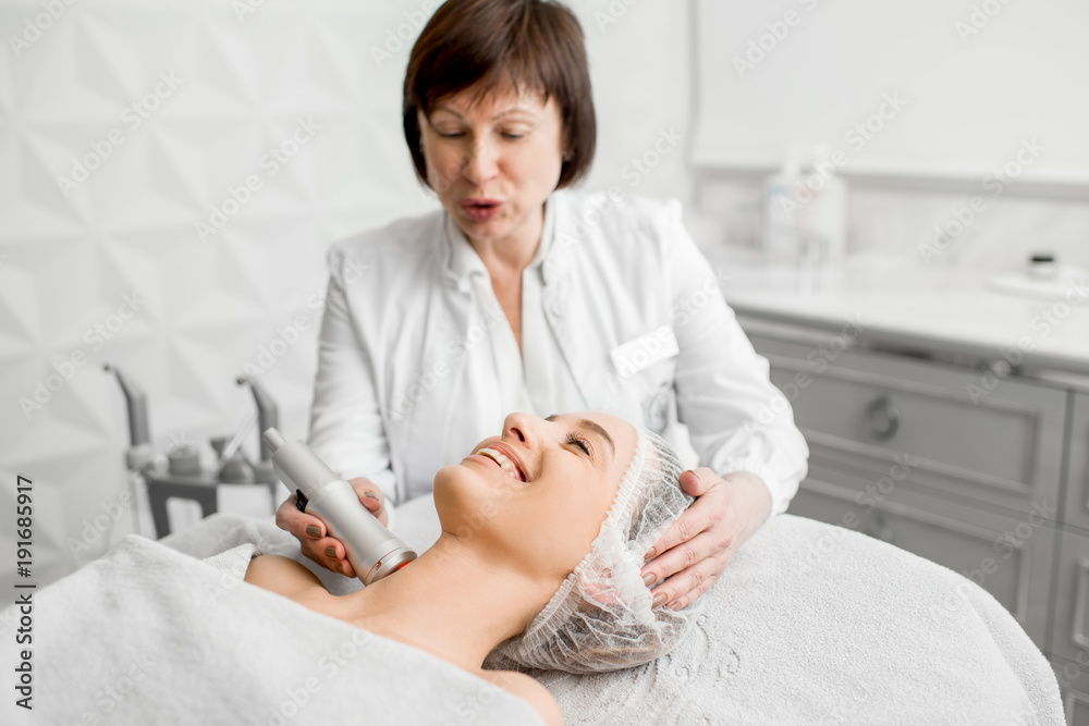 高级女美容师在豪华医疗度假酒店为一位年轻客户做面部手术