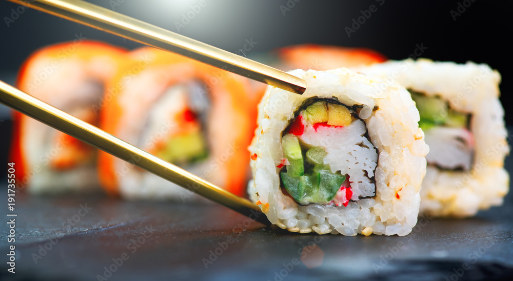 寿司卷。餐厅里的日本食物。寿司卷配三文鱼、蔬菜和飞行。