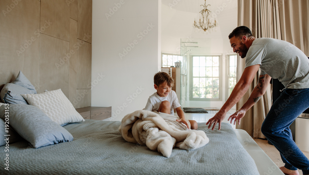 Father and son playing in bedroom