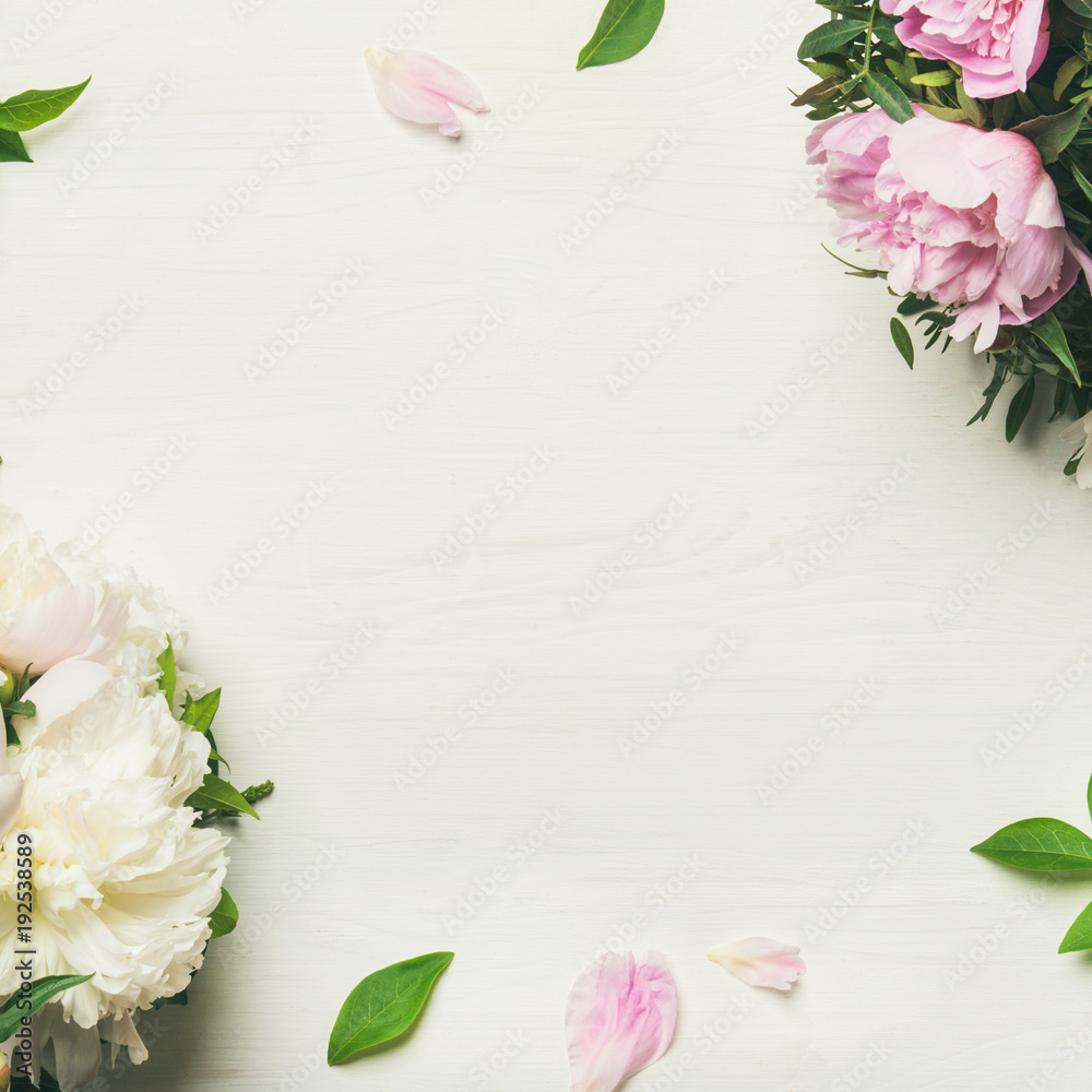 Spring flowers layout. Flat-lay of tender pale pink and white peonies over white background, top vie