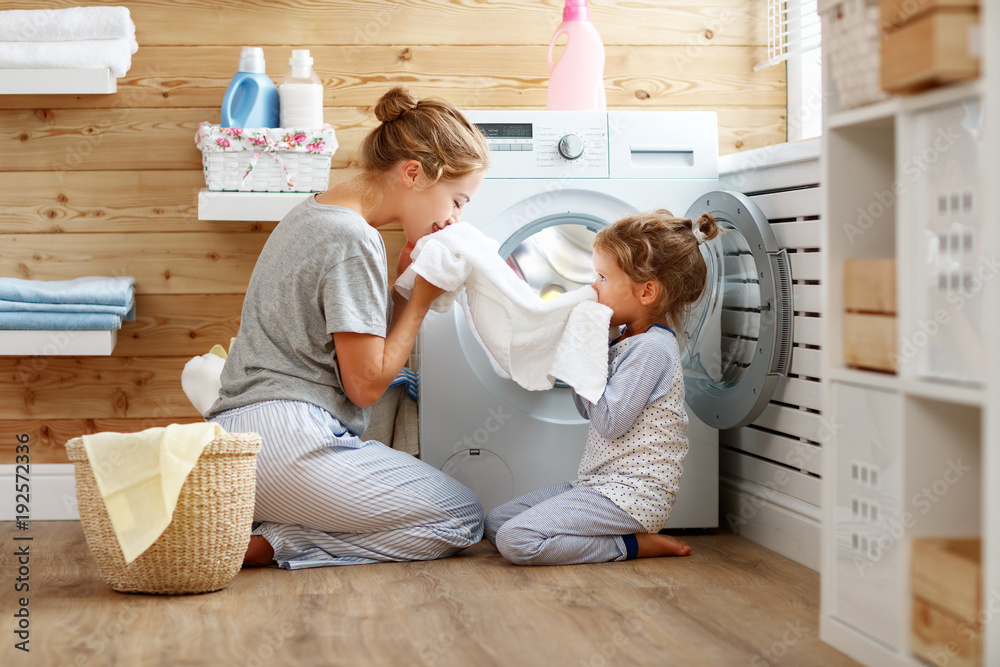 幸福家庭的母亲家庭主妇和孩子在洗衣机里