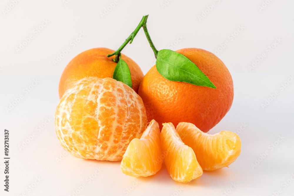 在白色背景上分离的整颗橘子或曼陀罗橙色水果和去皮的部分