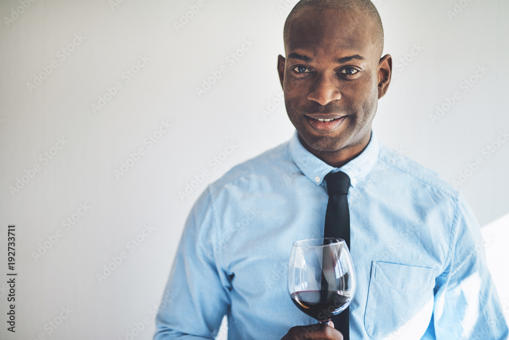 成熟男人微笑着喝着一杯红酒