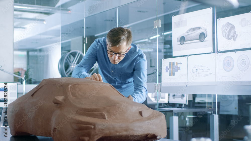 体验汽车设计师用Rake用塑性粘土雕刻原型汽车模型。他工作