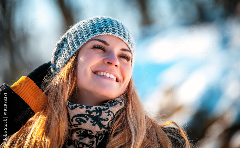 阳光明媚的冬日公园里微笑的女人的画像