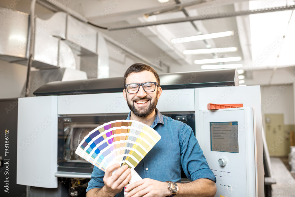 印刷厂印刷工人拿着色板站着的有趣画像