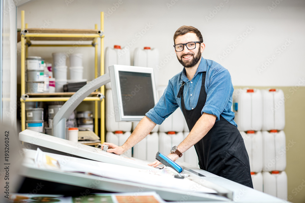 一名男性工人站在印刷厂操作台附近的肖像