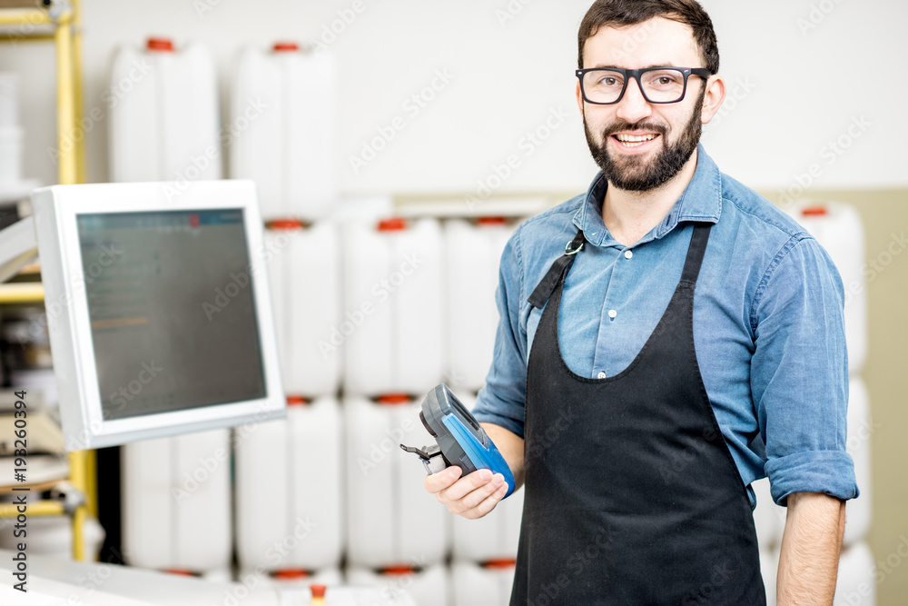 一名男性工人站在印刷厂操作台附近的肖像