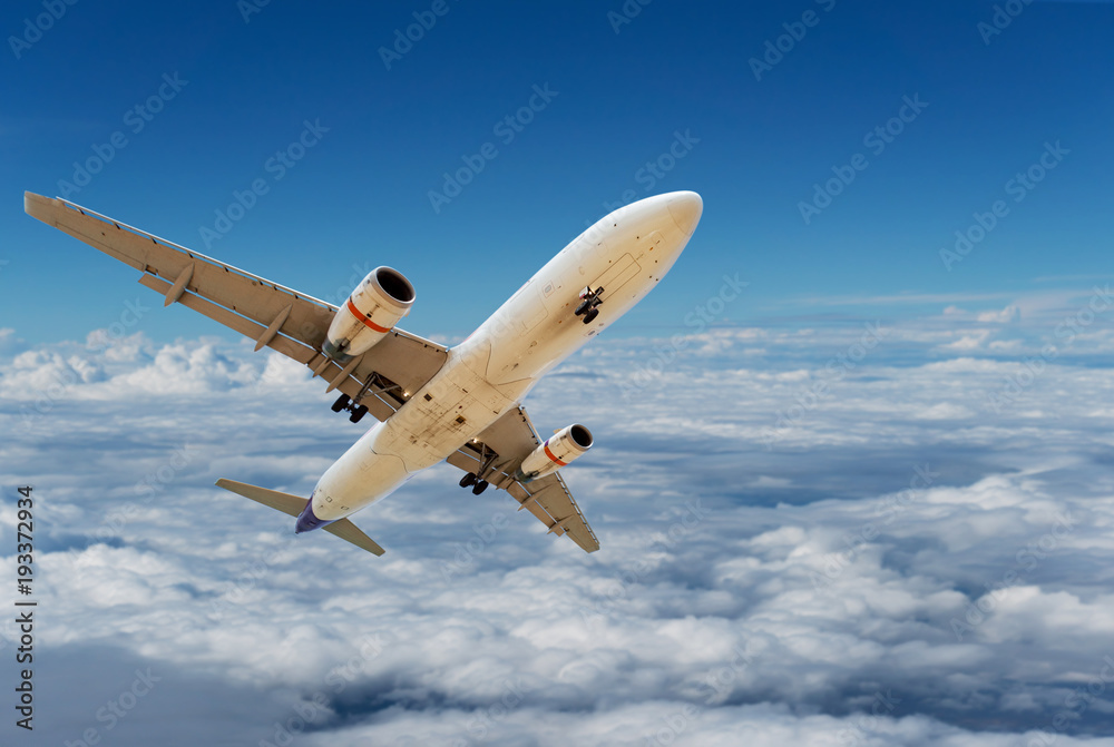 商用飞机在美丽的自然背景下，在云层和晴朗的蓝天上飞行。