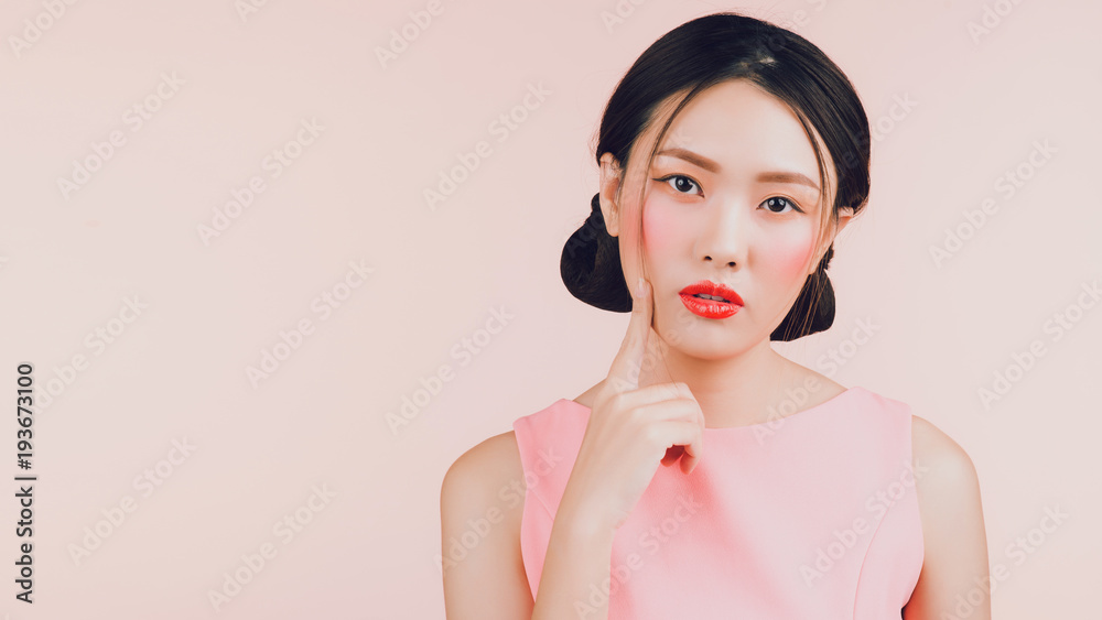 美丽的亚洲年轻女性，带着粉色隔离的时尚妆容。化妆品和化妆品