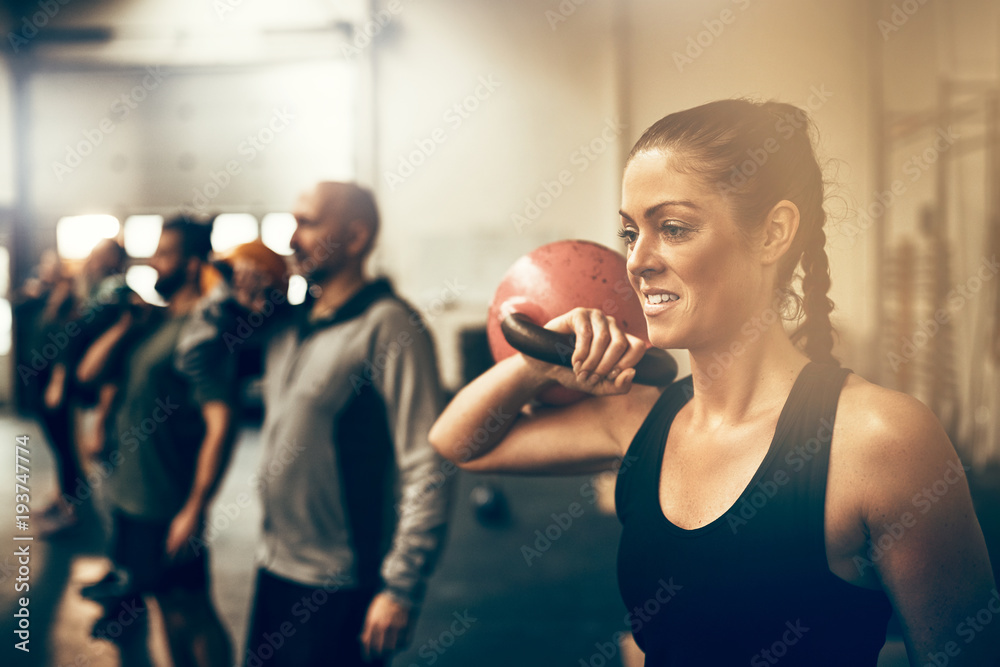健身女性在健身课上进行举重锻炼