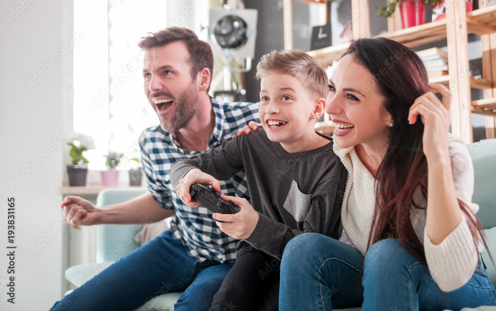 兴奋的家人在家里的游戏机上玩电子游戏