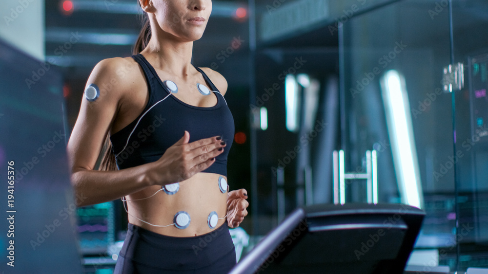 美女运动员在跑步机上跑步，身上绑着电极，女医生U