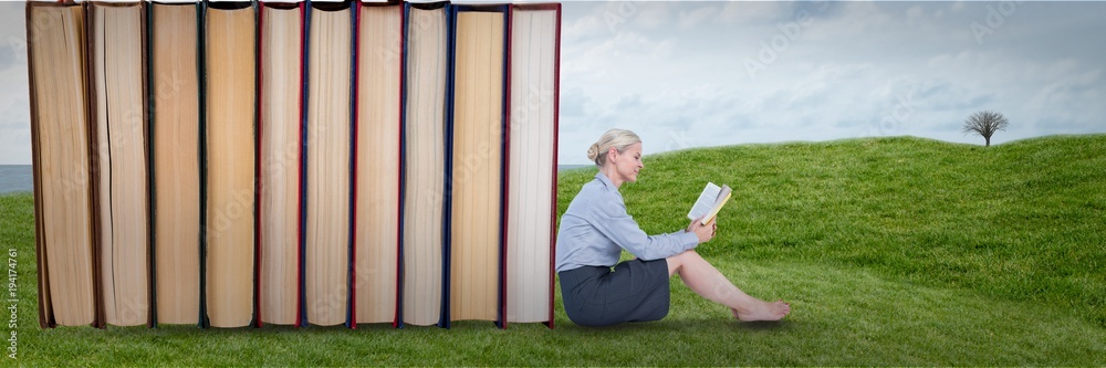 Business woman reading next to books outdoors