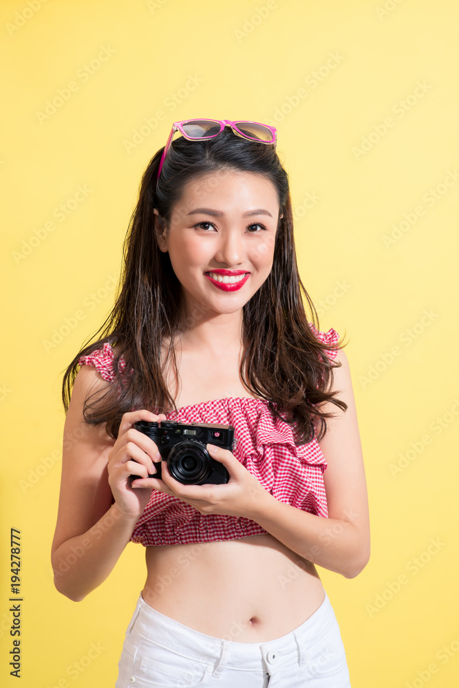 一位年轻模特的时尚肖像，留着湿漉漉的长发，拿着相机。