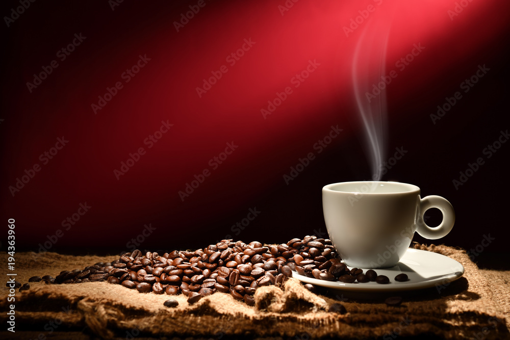 一杯烟熏咖啡和红棕色背景的咖啡豆