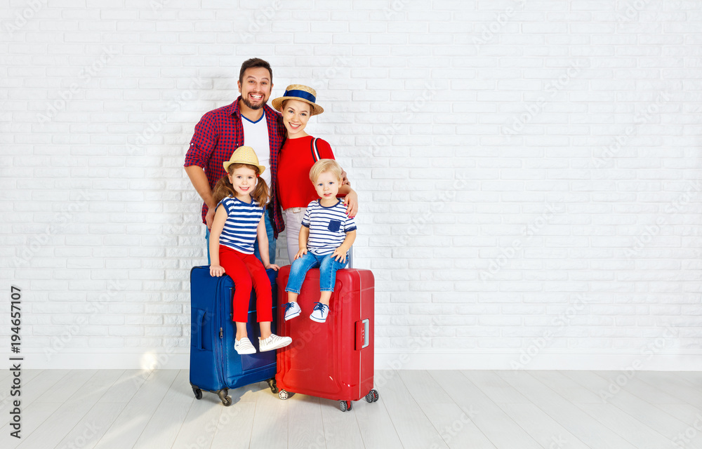 concept travel and tourism. happy family with suitcases near   wall