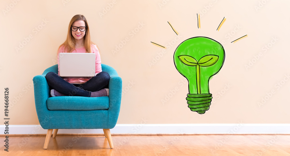 环保灯泡，年轻女子在椅子上用笔记本电脑