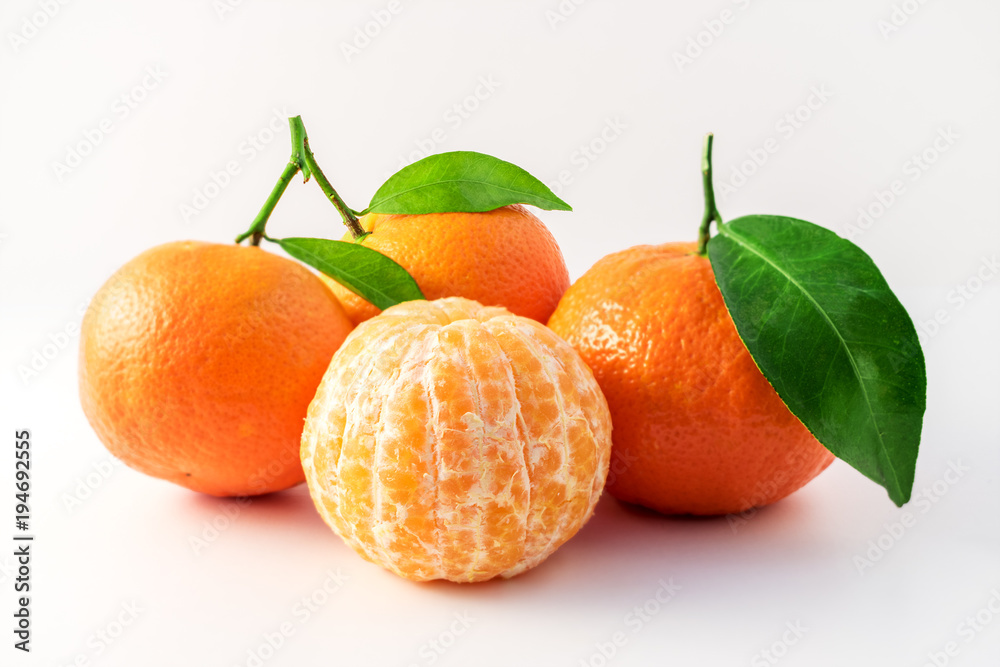 整颗橘子或曼陀罗的橙色果实和在白色背景上分离的去皮部分