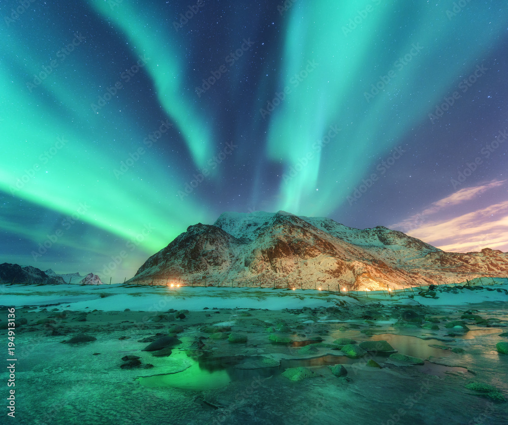 极光。挪威罗弗敦群岛的北极光。带极地灯光的星空。夜晚的冬季土地