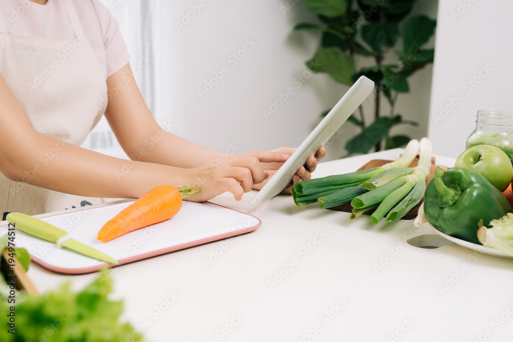 女人在厨房里使用数字平板电脑