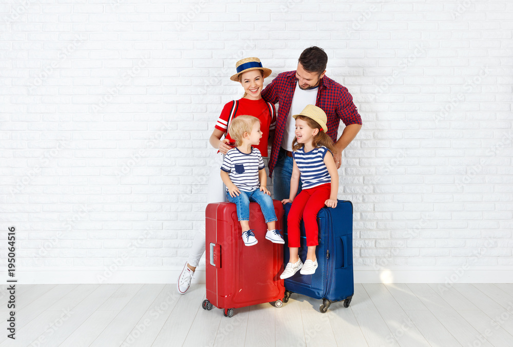 概念旅行和旅游。靠墙带行李箱的幸福家庭