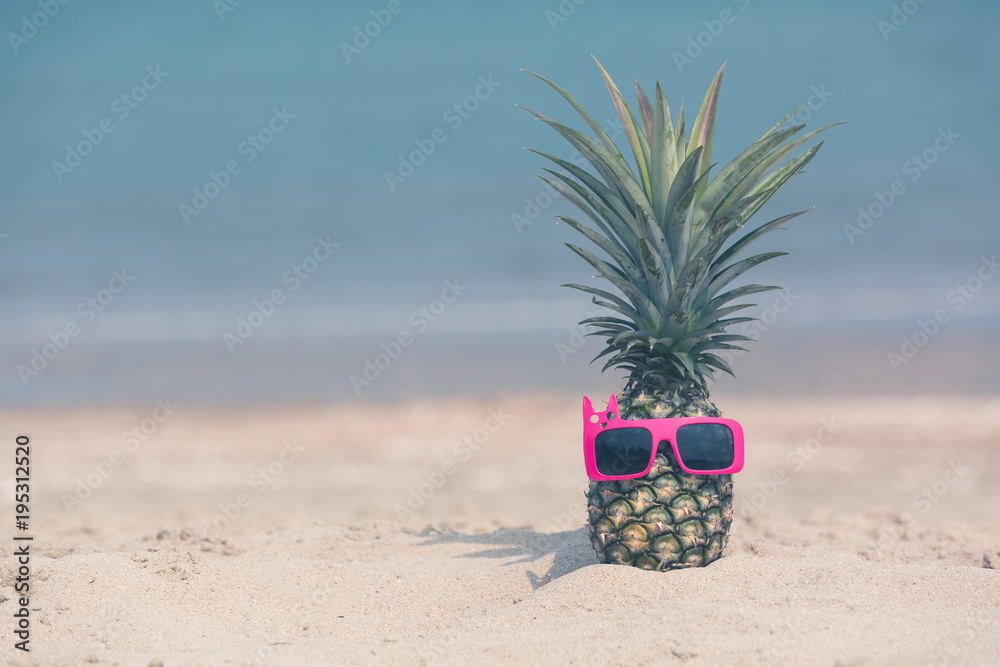 海滩上迷人的菠萝戴着时尚的镜面太阳镜，热带暑假骗局