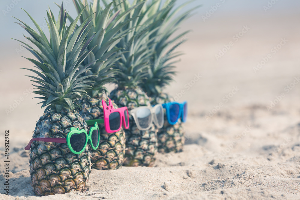 海滩上迷人的菠萝戴着时尚的镜面太阳镜，热带暑假骗局