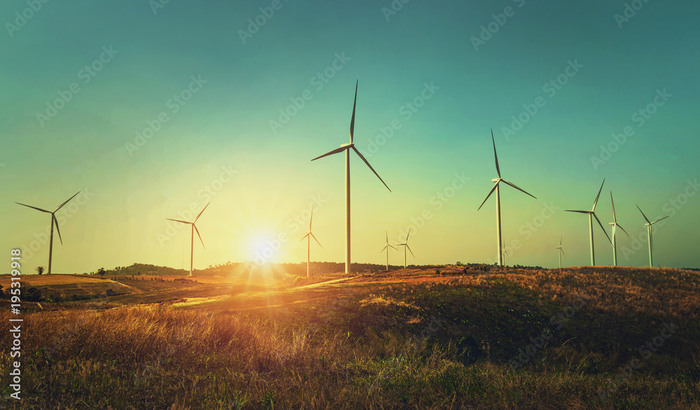 概念理念环保能源。日落时山上的风力涡轮机
