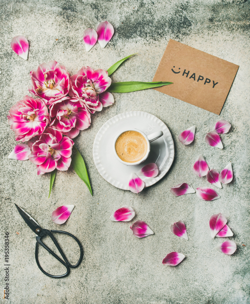 春天早晨的概念。一杯平坦的咖啡，周围是粉红色的郁金香花，标志着快乐
