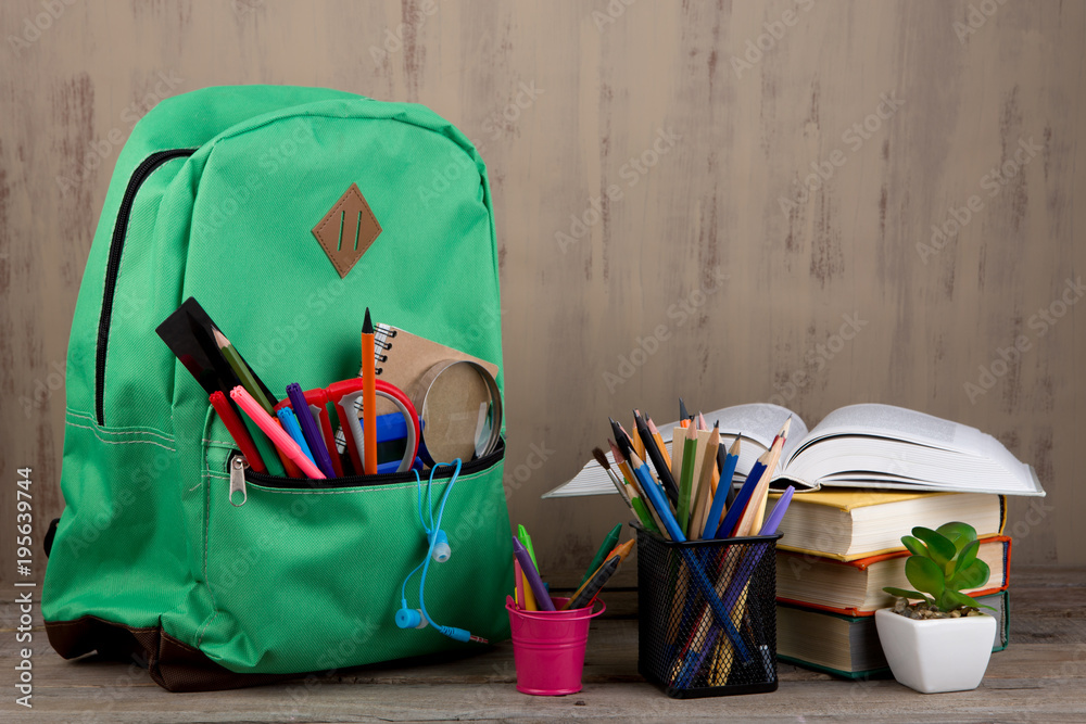 教育理念-学校背包，桌子上放着书和其他用品