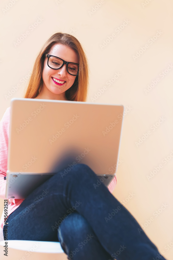 快乐的年轻女人在家里用笔记本电脑